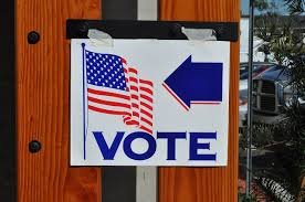 A sign with an American flag and the word "vote"