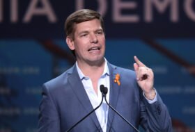 Eric Swalwell speaking from the podium at an event