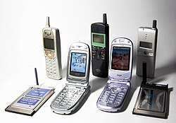 various old cellphones and flip phones against a white background