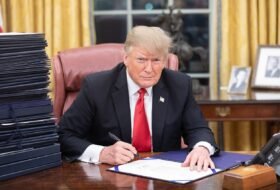 Trump sitting at his desk in the oval office